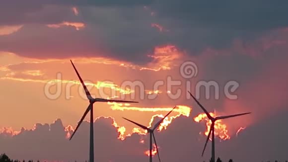 风力涡轮机在日落时在田野里旋转视频的预览图