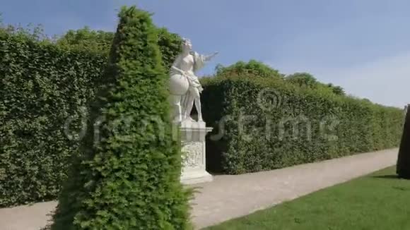 在美丽的花园里拍摄的Stadicam围绕着一个女人的白色古董雕像视频的预览图