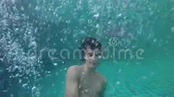 年轻人在水下游泳水滴在惊人的蓝色海洋中飘落和飞溅慢动作120fps1920x1080视频的预览图