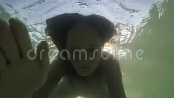 漂亮的年轻快乐的女人在热带海洋中通过太阳在水下游泳慢动作1920x1080视频的预览图
