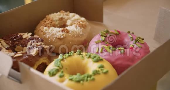 带外卖的盒子里有美味甜蜜五颜六色的甜甜圈视频的预览图