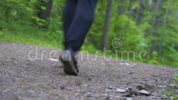 人沿着森林里的小路跑摄像机从下面拍摄视频的预览图