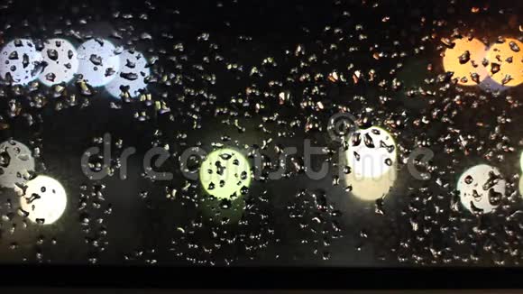 夜晚灯光下玻璃上的雨滴视频的预览图