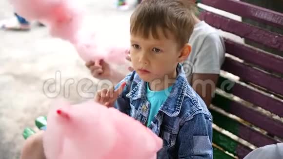 孩子们在公园里吃棉花糖香甜可口的甜点孩子出生的那一天视频的预览图