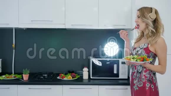 穿着睡衣的女孩带着耳机在厨房跳舞手里拿着一盘沙拉视频的预览图