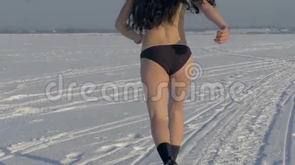 一个身材苗条的女人穿着比基尼在冬天跑步视频的预览图