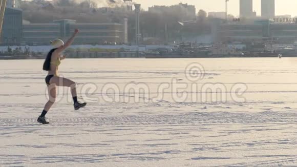 一个穿泳衣的快乐女人跳过雪地视频的预览图