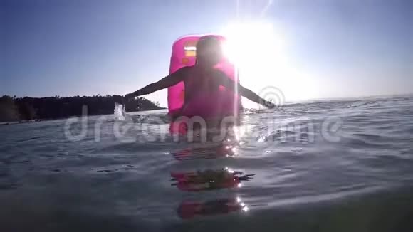 年轻快乐的女人在充气床垫上放松在海上泼水在假期里玩得很开心超级慢动作视频的预览图