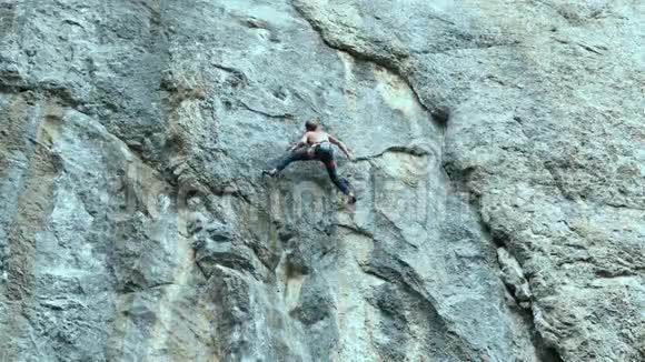 强壮的肌肉男攀岩者在户外运动路线上攀登垂直悬崖视频的预览图