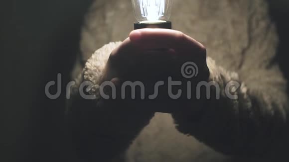 他手里拿着一盏发光的爱迪生灯照相机动作缓慢视频的预览图