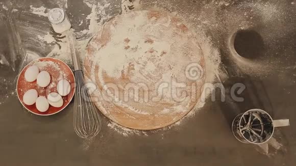 女性手的特写镜头把新鲜的面包放在桌子上面粉撒得到处都是鸡蛋放在红盘子上视频的预览图