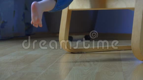 赤脚的孩子从扶手椅上下来步履蹒跚视频的预览图