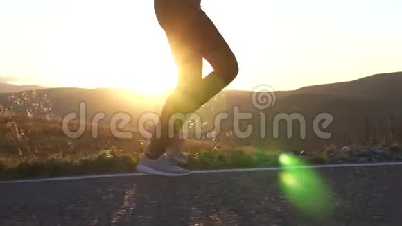 日落时分女孩在山上的道路上奔跑双腿紧闭视频的预览图