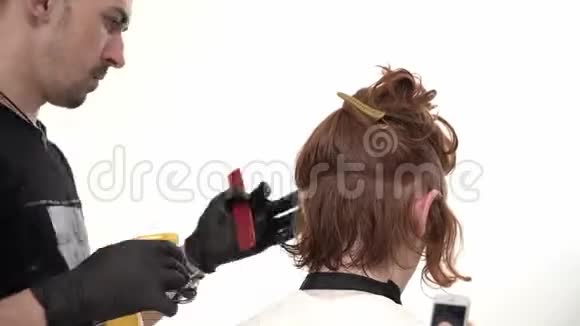 理发师使一个时尚的发型好男人长红色头发视频的预览图