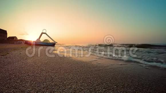 海上日出双体船站在海边的海滩上一个夏天的早晨沙滩被海浪冲走了视频的预览图