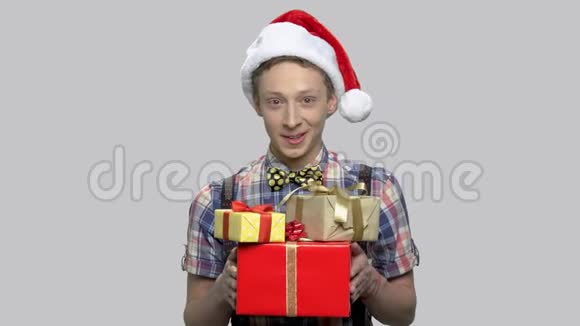 戴圣诞帽的男孩送礼物盒视频的预览图