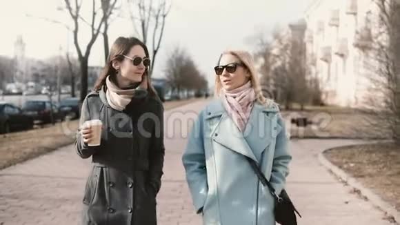 两个年轻快乐的高加索女人走在一起女朋友在街上聊天女商人在外面开会视频的预览图
