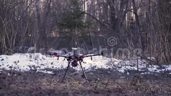黑色四翼飞机从森林中的地面起飞许多叶子飞向两侧剪辑一架无人机开始视频的预览图