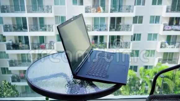 玻璃桌面特写的黑色笔记本电脑视频的预览图