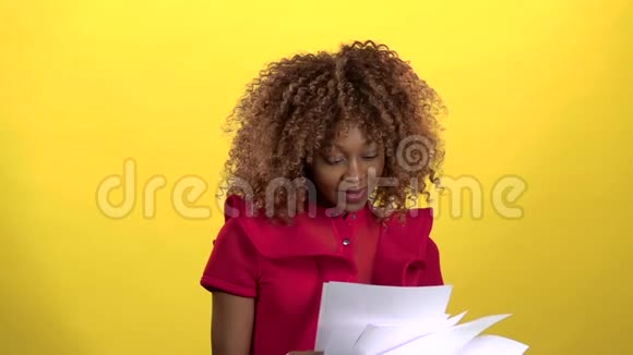 女商人非裔美国人扔纸和喜悦黄色背景慢动作视频的预览图