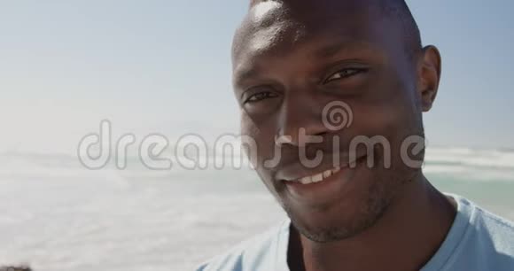 在海滩上看摄像机的男性志愿者视频的预览图