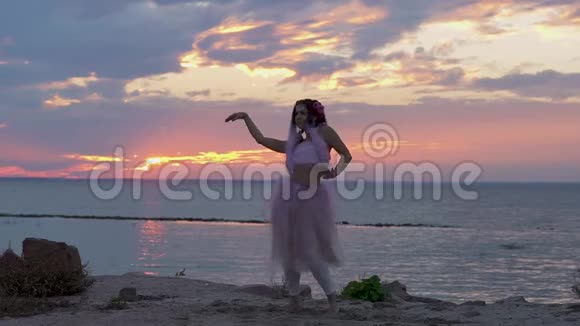可爱的女人妆容鲜艳穿着粉红色的连衣裙在河岸上跳舞一个性感女孩和一个视频的预览图