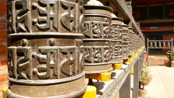 尼泊尔Durbar广场寺庙院子里的一排带咒的古老宗教祈祷轮或鼓视频的预览图