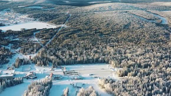 冬季森林环绕的滑雪场停车场和酒店景观录像户外运动视频的预览图