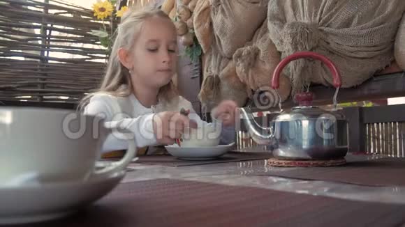 可爱的小女孩在咖啡馆喝茶清淡的早餐小白种人女孩在咖啡馆喝茶视频的预览图