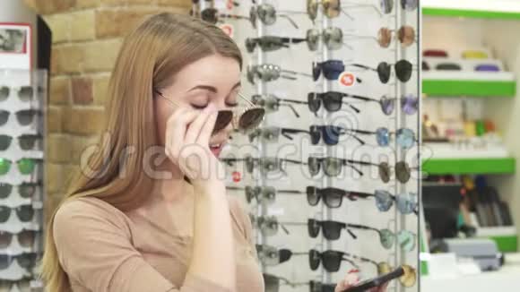 快乐的年轻女人在买眼镜的时候吃自拍视频的预览图