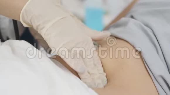 医生检查躺在医院里的病人的腹部视频的预览图