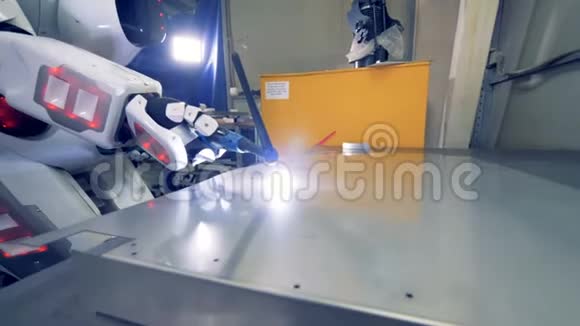 白色机器人使用焊接工具特写特殊机器人在工厂工作焊接金属片视频的预览图