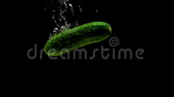 绿色黄瓜在黑色背景下落入透明水视频的预览图