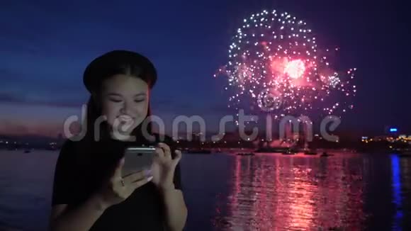 快乐女孩在烟花背景下使用电话视频的预览图