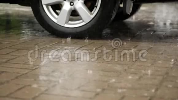 汽车车轮的特写汽车在停车场被润湿大的水滴随着溅落到水坑里有沉重的视频的预览图
