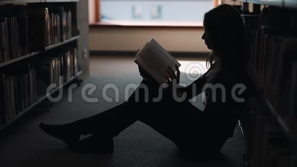 女孩坐在地板上在图书馆看书视频的预览图