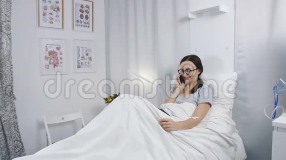 医院里的那个女人躺在床上和亲戚通电话视频的预览图