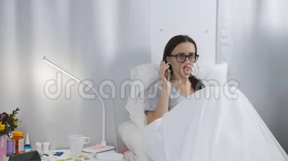 医院里的那个女人躺在床上和亲戚通电话视频的预览图