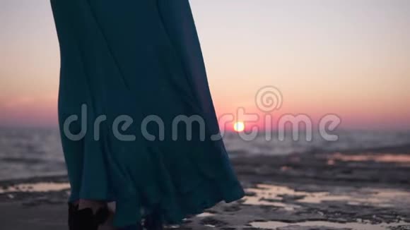一个穿着连衣裙的孤独女孩在码头上的海面上遇见了黎明这件衣服植根于太阳的背景视频的预览图