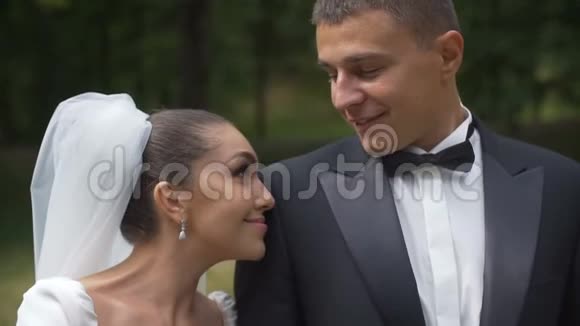 幸福美丽新婚夫妇的浪漫肖像新娘温柔地靠在她的肩膀上视频的预览图