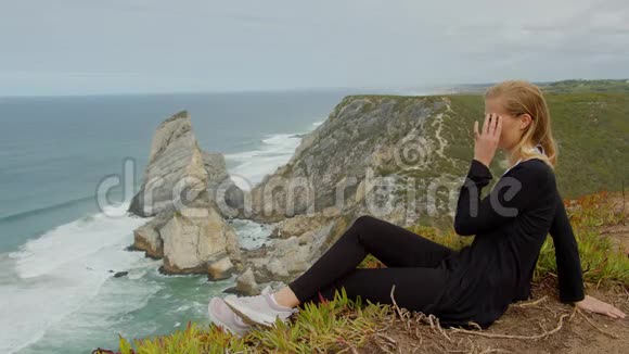 在葡萄牙的CabodaRoca年轻女子欣赏海景视频的预览图