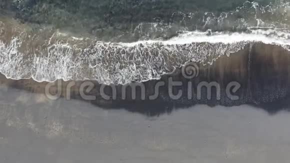 平静的海浪翻滚成黑色的沙滩海岸天堂视频的预览图