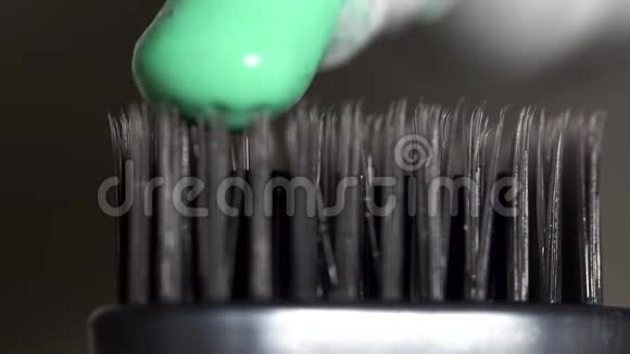 在深灰色背景下用绿色牙膏从试管中挤出来的灰色牙刷牙齿视频的预览图