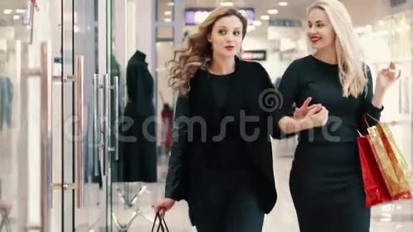 两个女人在店面附近的商店里挑选衣服视频的预览图