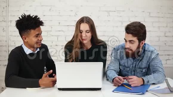 各种各样的年轻企业家在办公室里讨论使用笔记本电脑的生意两个人正在争吵视频的预览图