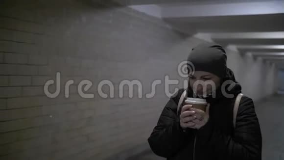 漂亮的女人穿过肮脏可怕的隧道想着什么好东西喝咖啡冬天视频的预览图