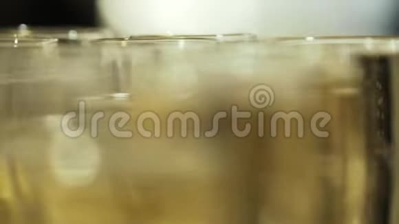 近景模糊的香槟酒杯与凉爽美味的香槟或白起泡酒在桌子上行动视频的预览图