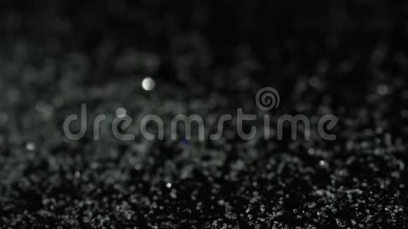 黑色背景上闪闪发光的玻璃颗粒的特写库存录像白色和黑色的概念视频的预览图