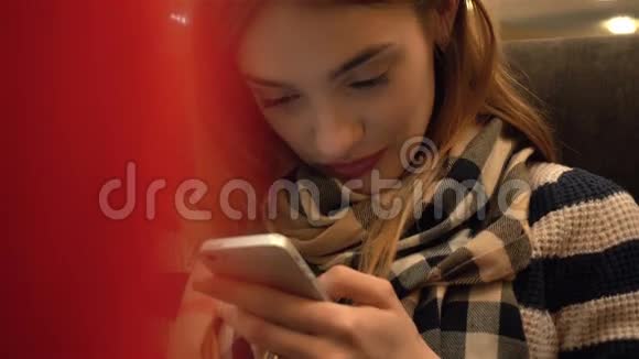 幸福的年轻女子微笑着看着她的手机在家视频的预览图