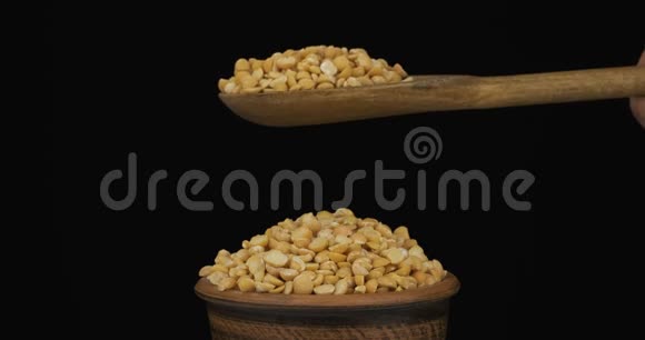 豌豆粒从一个木勺上得到足够的睡眠在一堆泥土碗里的种子视频的预览图